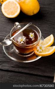 photo of delicious lemon tea with lemon slices and marguerite inside