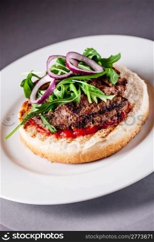 Photo of delicious light burgher with meat and arugula salad