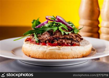 Photo of delicious light burgher with meat and arugula salad