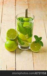 photo of delicious mojito cocktail with cuttd lime on wooden table