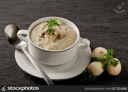 photo of delicious mushroom cream soup with parsley on grey towel