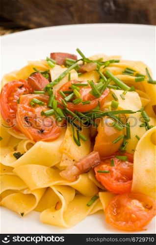 photo of delicious pasta with bacon and tomatoes