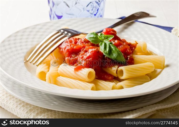 photo of delicious pasta with basil and tomato sauce on white wooden table