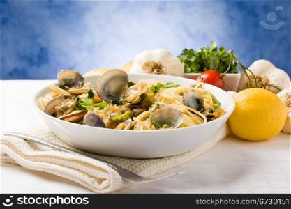 photo of delicious pasta with clams in front of a blue background