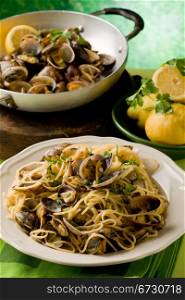 photo of delicious pasta with clams in front of a green background