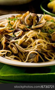 photo of delicious pasta with clams in front of a green background