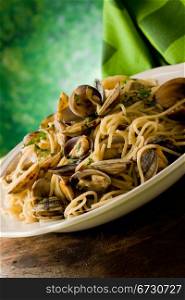 photo of delicious pasta with clams in front of a green background