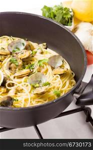photo of delicious pasta with clams inside a pan on cooker