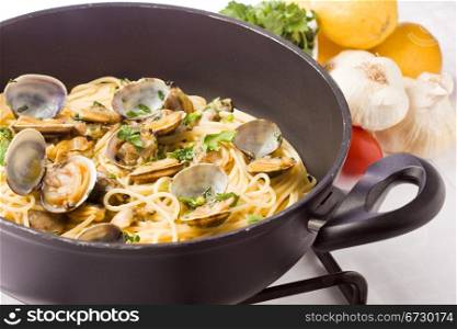 photo of delicious pasta with clams inside a pan on cooker