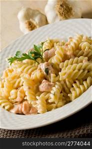 photo of delicious pasta with salmon and cream on wooden background