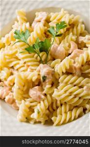 photo of delicious pasta with salmon and cream on wooden background