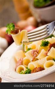 photo of delicious pasta with sausage and broccoli on wooden table