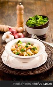 photo of delicious pasta with sausage and broccoli on wooden table
