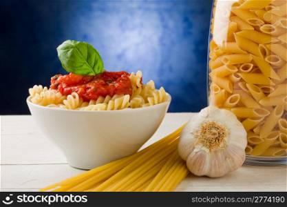 photo of delicious pasta with tomato sauce on blue background