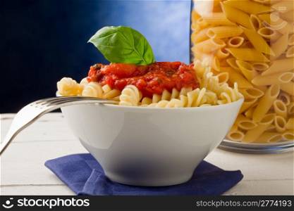 photo of delicious pasta with tomato sauce on blue background