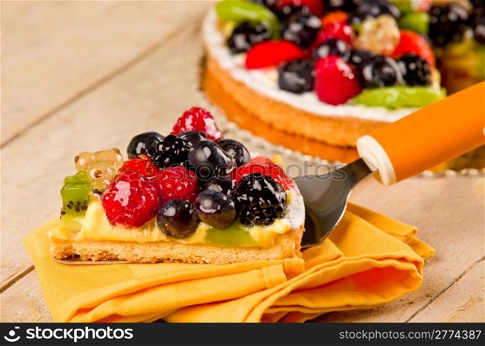 photo of delicious pie with various fruits on wooden table