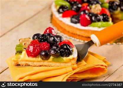 photo of delicious pie with various fruits on wooden table