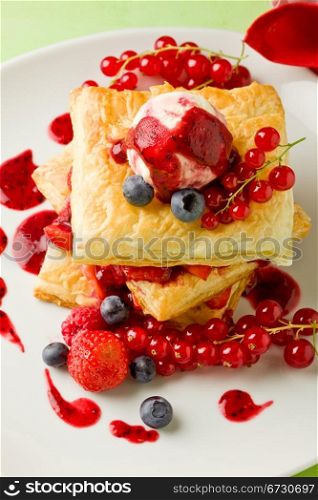 photo of delicious puff pastry with berries and ice cream