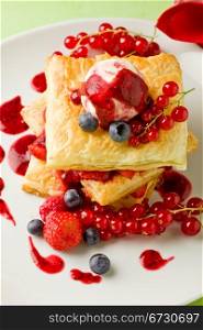 photo of delicious puff pastry with berries and ice cream