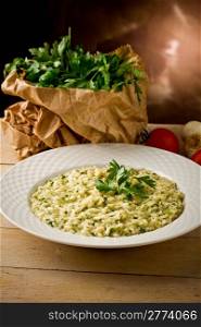 photo of delicious risotto dish with herbs on wooden table
