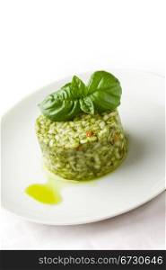 photo of delicious risotto with basil on white isolated background