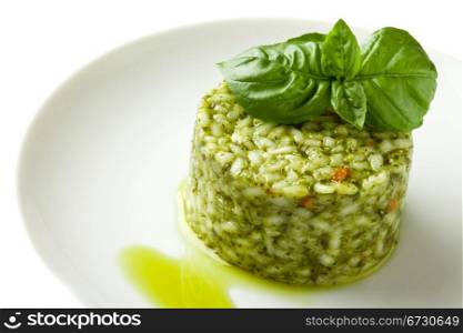 photo of delicious risotto with basil on white isolated background