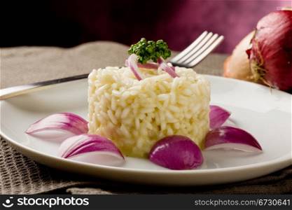 photo of delicious risotto with red onions on wooden table