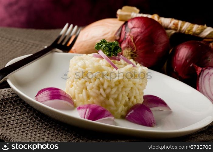 photo of delicious risotto with red onions on wooden table