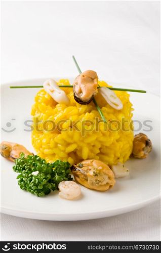 photo of delicious risotto with saffron and seafood on white isolated background