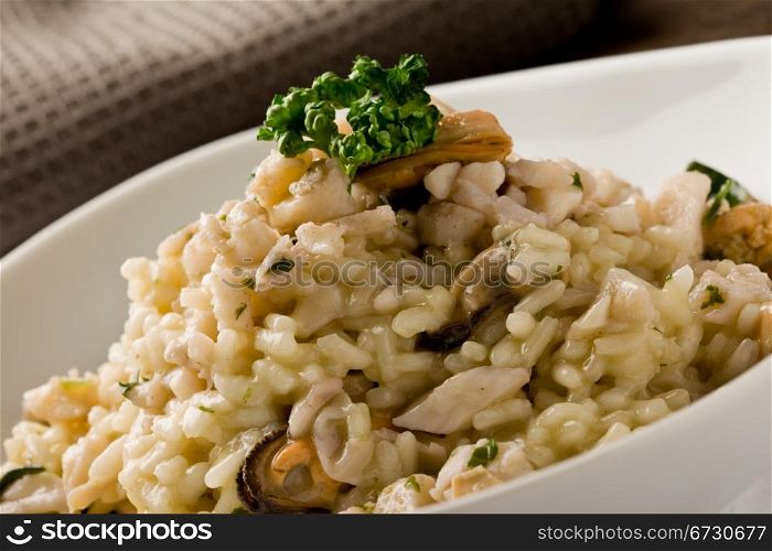 photo of delicious risotto with seafood and parsley on it