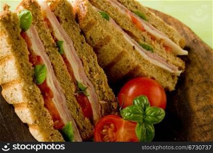 photo of delicious sandwich with cheese and ham on wooden table