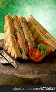 photo of delicious sandwich with cheese and ham on wooden table