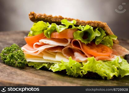 photo of delicious sandwich with smoked bacon and cheese on wooden table