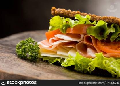 photo of delicious sandwich with smoked bacon and cheese on wooden table
