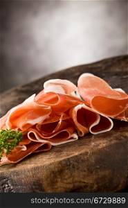 photo of delicious sliced bacon on wooden table with parsley