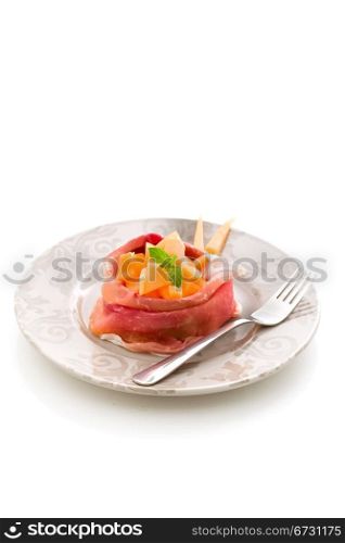 photo of delicious sliced bacon with melon inside on white isolated background