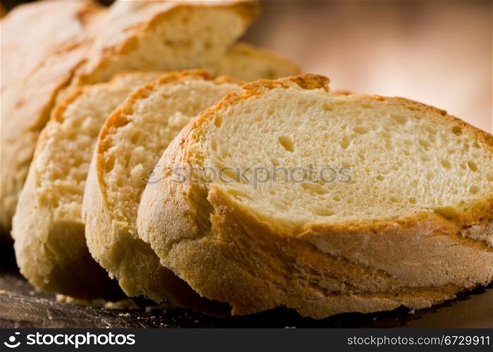 photo of delicious sliced bread on wooden table with knife