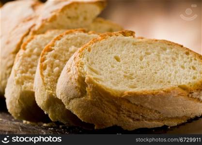photo of delicious sliced bread on wooden table with knife