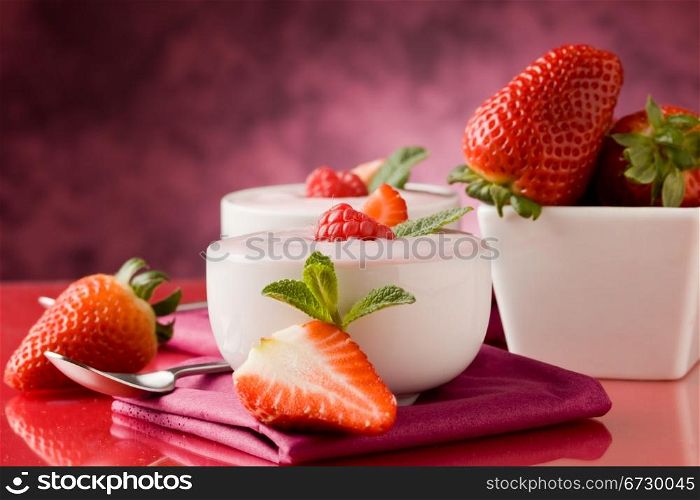 photo of delicious strawberry yogurt on red glass table