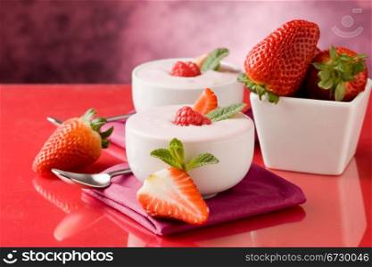 photo of delicious strawberry yogurt on red glass table
