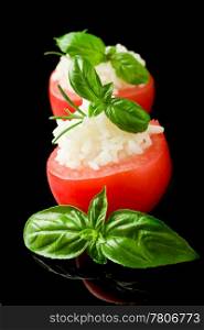 photo of delicious stuffed tomatoes with rice on black isolated background
