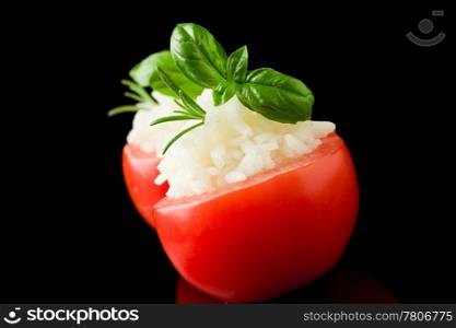 photo of delicious stuffed tomatoes with rice on black isolated background