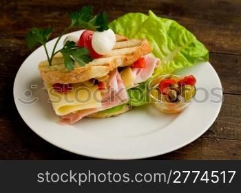 photo of delicious toast stuffed with cheese and ham with lettuce and parsley