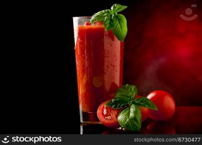 photo of delicious tomato bloody mary cocktail on reflecting glass table with spot light