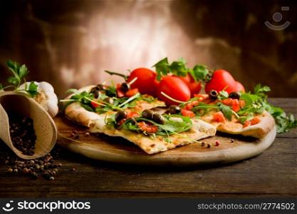 photo of delicious vegetarian pizza with arugula on wooden table