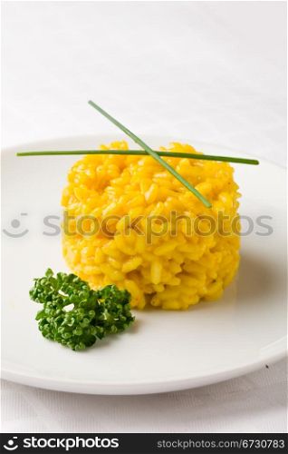 photo of delicious yellow risotto with saffron on white isolated background