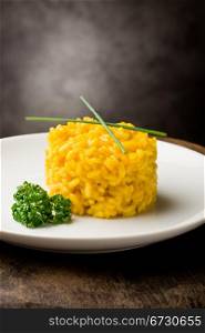 photo of delicious yellow risotto with saffron on wooden table