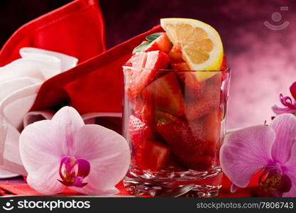 photo of delicius cutted strawberries with sliced lemon and orchid flower