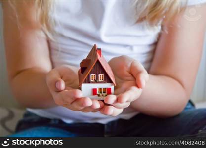 Photo of dollhouse in human hand on white background