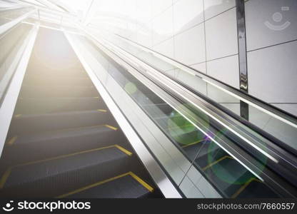Photo of escalator with lens flare in background